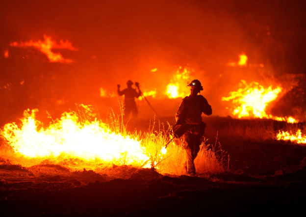 A firefighter lights a backfire as the Rocky Fire burns near Clearlake, Calif., on Monday, Aug. 3, 2015. The fire has charred more than 60,000 acres and destroyed at least 24 residences. (AP Photo/Josh Edelson)